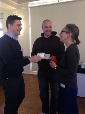 Happy facilitators sharing a tea and a biscuit before the start of the event